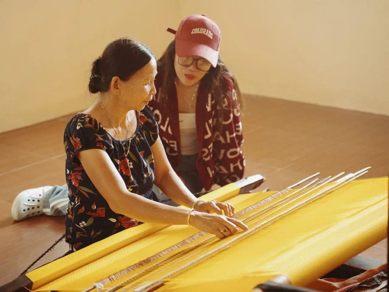 Du khách đang tận mắt chứng kiến các kỹ thuật dệt thổ cẩm của các nghệ nhân trong làng nghề.