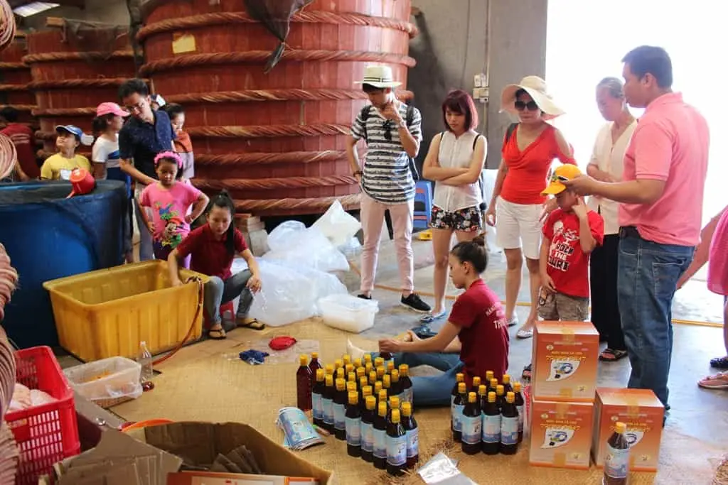 Du khách trải nghiệm nếm thử nước mắm cốt nguyên chất ngay tại nhà thùng