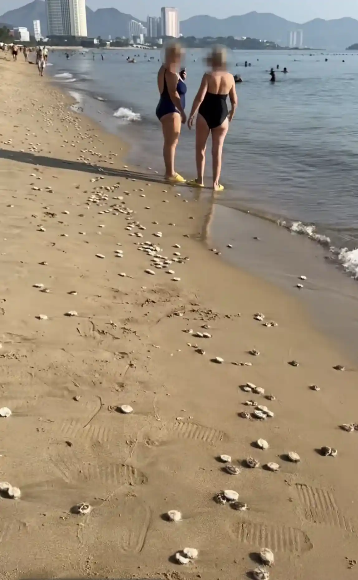 Du khách mang dép đi dạo bãi biển Nha Trang đảm bảo an toàn